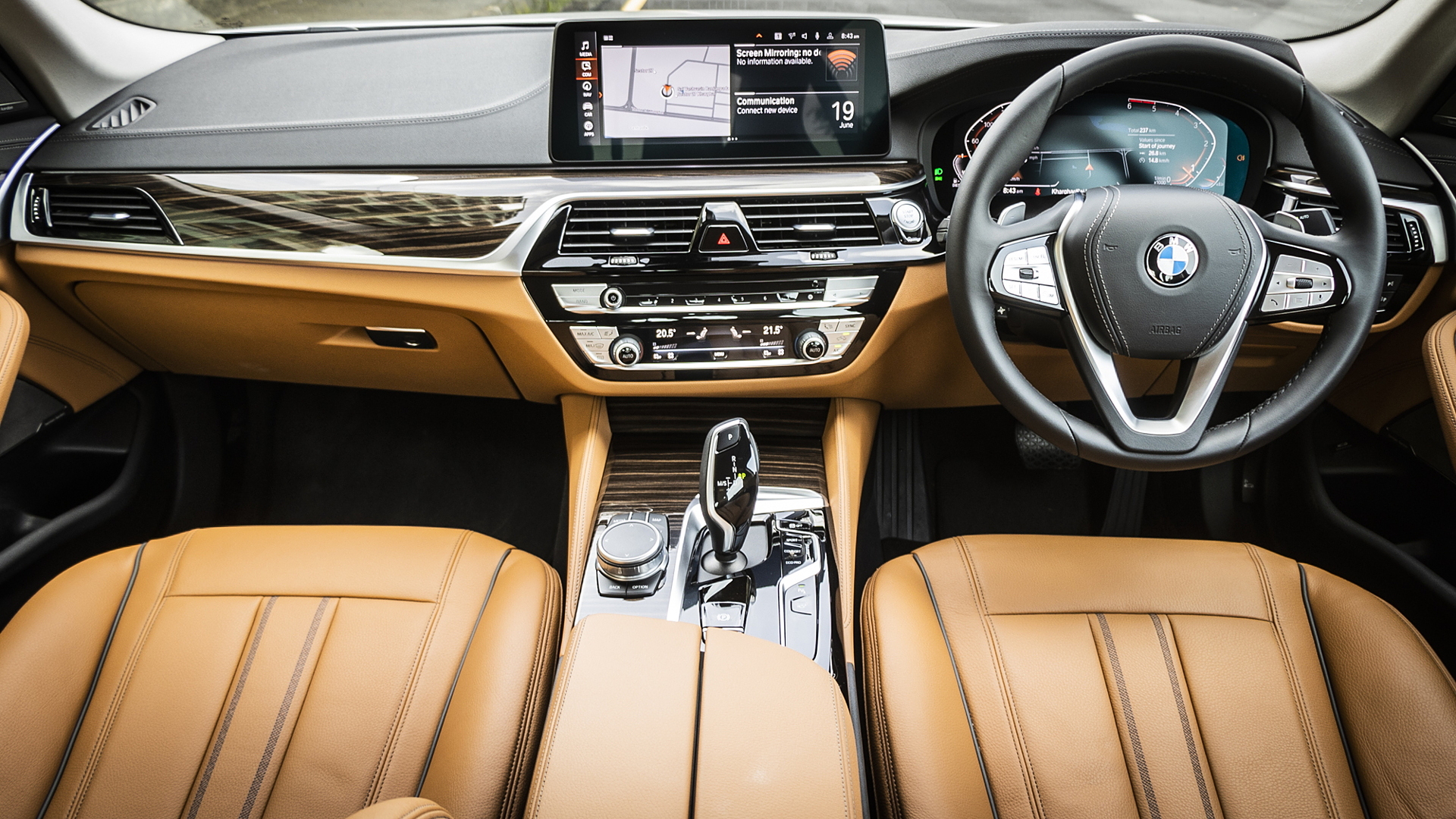Luxurious car interior featuring tan leather seats, a sleek dashboard, a digital display, and a modern gear shifter.