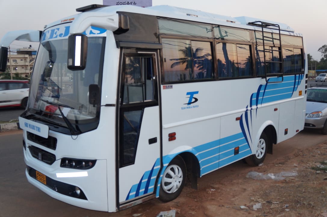 A white and blue bus parked on the roadside, displaying the name "Sri Maruthi" on the front.